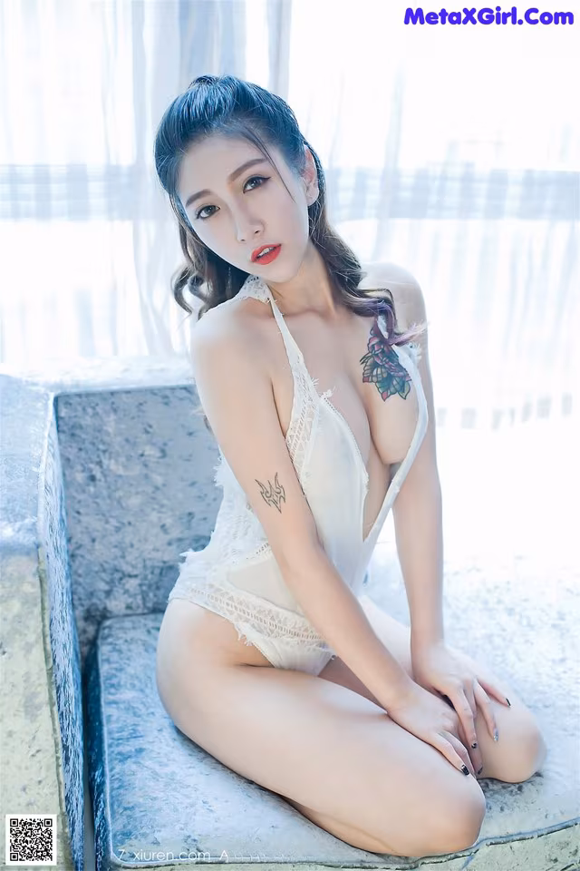 A woman in a white lingerie sitting on a ledge.