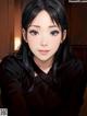 A woman with long black hair and a black shirt.