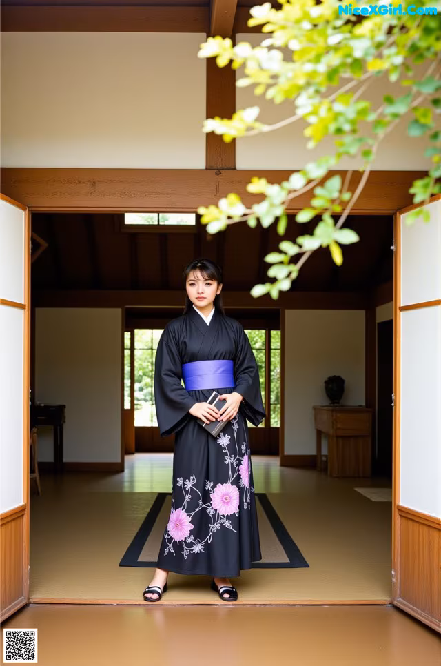 A woman in a black and purple kimono standing in a room.