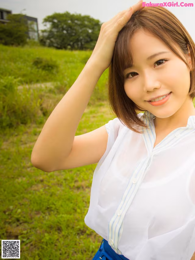 A woman in a white shirt and blue skirt posing for a picture.