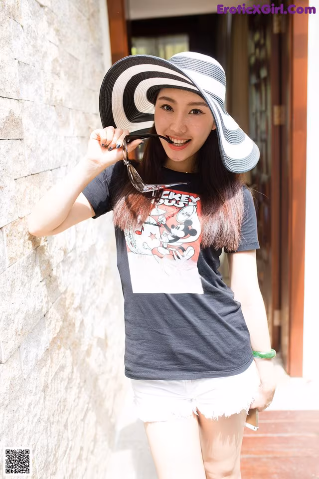A woman wearing a black and white striped hat and sunglasses.