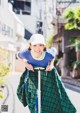 A woman riding a scooter down a street.