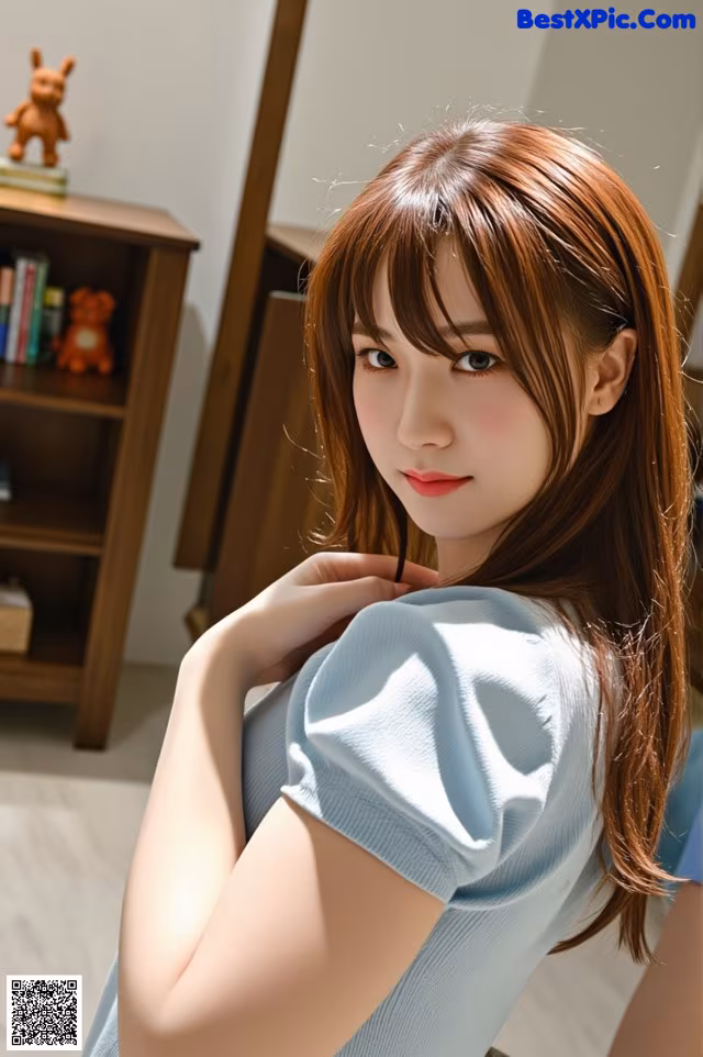 A woman in a blue shirt is posing for a picture.