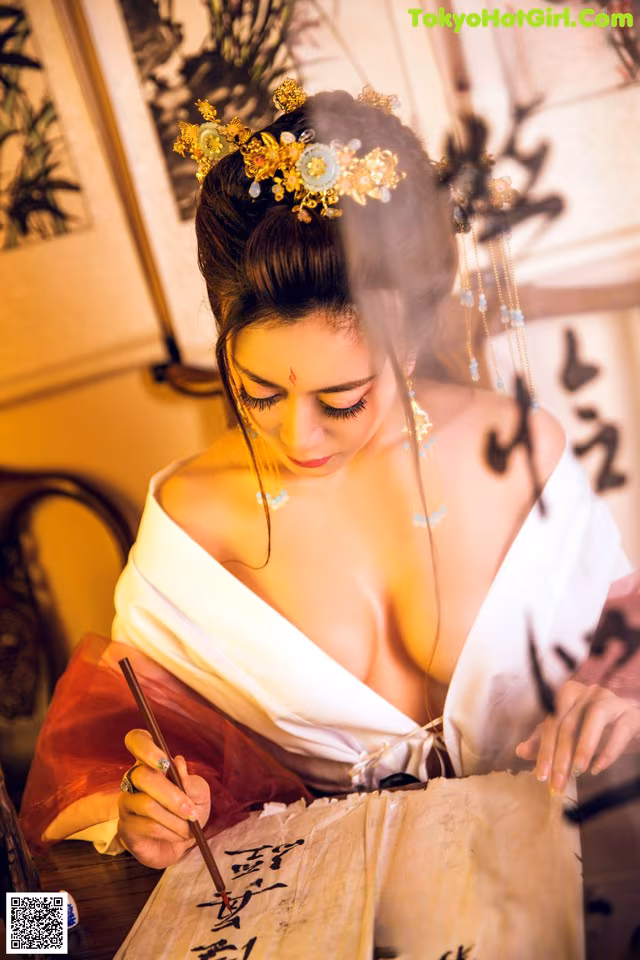 A woman in a white dress writing on a piece of paper.