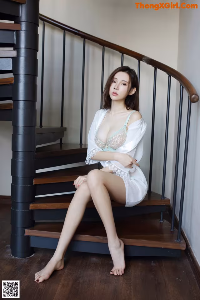 A woman sitting on the stairs of a house.