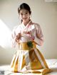 A woman in a pink and yellow hanbok is posing for a picture.